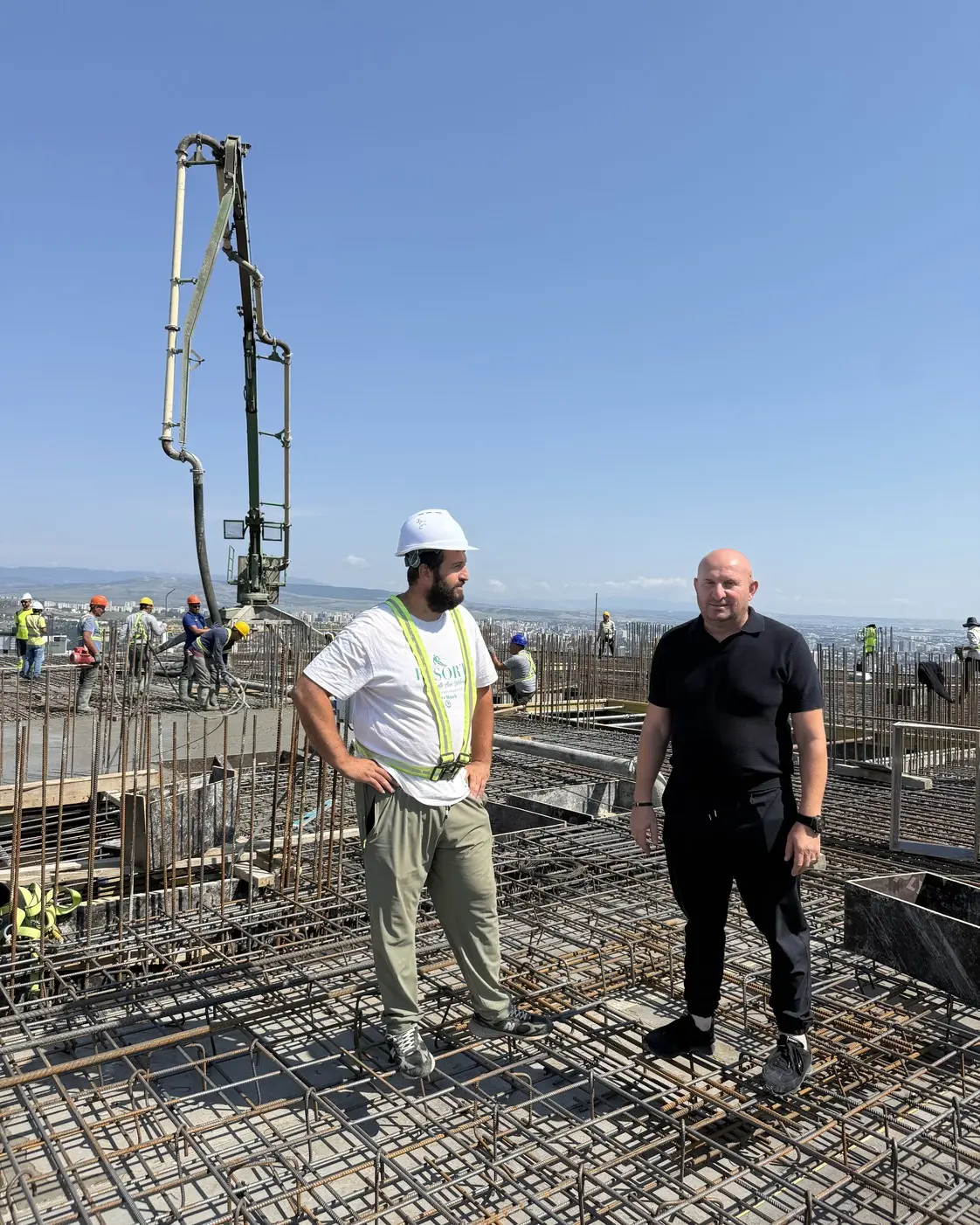 ONEZA Construction-ის დამფუძნებელი გიორგი ონეზაშვილი (მარჯვნივ, შავებში) დაარმატურებულ გადახურვის ფილაზე, მოედანი კრწანისში, თბილისი